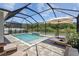 Inviting screened pool features a sun shelf and relaxing lounge chairs with picturesque greenery in the background at 3161 Satilla Loop, Odessa, FL 33556