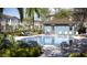 Community pool with lots of lounge chairs with a covered patio area nearby at 36068 Risa Michele St, Zephyrhills, FL 33541
