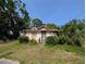 Quaint single-story home featuring a secure metal door, framed windows, and a verdant front yard with mature trees at 3706 N 36Th St, Tampa, FL 33610