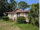 Inviting single-story home with secure metal door, framed windows, and a vibrant garden with mature tropical landscaping at 3706 N 36Th St, Tampa, FL 33610