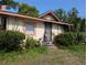 Single-story home with security door, framed windows, and natural landscaping with a tidy lawn and surrounding shrubbery at 3706 N 36Th St, Tampa, FL 33610