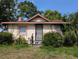 Charming single-story home with a secure metal door and a lush garden surrounding the front entrance at 3706 N 36Th St, Tampa, FL 33610
