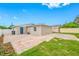 View of the backyard showing the back of the house, small tree and paved area at 3927 Spence Ave, Tampa, FL 33614