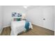 Cozy bedroom featuring cool-toned wall art over the bed and light-colored wood flooring for a serene atmosphere at 3927 Spence Ave, Tampa, FL 33614