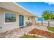Welcoming single-story home featuring a blue door, charming chairs, and a well-maintained outdoor space at 3927 Spence Ave, Tampa, FL 33614