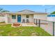 Charming single-story home with blue door, gray chairs, tidy landscaping, and a welcoming walkway at 3927 Spence Ave, Tampa, FL 33614