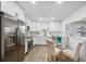 Updated kitchen with stainless appliances, white cabinets, quartz counters and view of dining nook at 3927 Spence Ave, Tampa, FL 33614