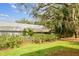 Landscaped backyard with mature trees and green grass at 39650 Us Highway 19 N # 143, Tarpon Springs, FL 34689