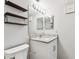 Bright bathroom features granite countertop, floating wood shelves, and vanity lighting at 39650 Us Highway 19 N # 143, Tarpon Springs, FL 34689