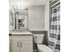 Bathroom with a granite countertop vanity, toilet and shower with gray and white striped curtain at 39650 Us Highway 19 N # 143, Tarpon Springs, FL 34689