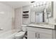 Bathroom with tub-shower, granite countertop vanity, toilet, and tiled walls at 39650 Us Highway 19 N # 143, Tarpon Springs, FL 34689
