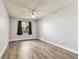Bright bedroom features vinyl flooring, a ceiling fan, and natural light from the window at 39650 Us Highway 19 N # 143, Tarpon Springs, FL 34689
