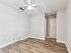 Bright bedroom with a ceiling fan, wood-look flooring and neutral-painted walls at 39650 Us Highway 19 N # 143, Tarpon Springs, FL 34689