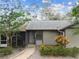 Single-story home with a gray exterior, well-maintained landscaping, and a walkway leading to the front entrance at 39650 Us Highway 19 N # 143, Tarpon Springs, FL 34689