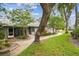 Single-story home with charming walkway, green lawn, and mature trees at 39650 Us Highway 19 N # 143, Tarpon Springs, FL 34689
