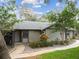 Charming single-story home featuring a beautifully landscaped front yard with mature trees and a welcoming walkway at 39650 Us Highway 19 N # 143, Tarpon Springs, FL 34689