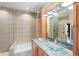 Luxurious bathroom with double glass vessel sinks, wood cabinets, and tiled accent wall at 400 4Th S Ave # 508, St Petersburg, FL 33701