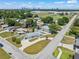 Aerial view of a well-kept home with a paved driveway, fenced yard, and surrounding greenery at 4005 W Coachman Ave, Tampa, FL 33611