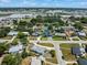An aerial view shows the neighborhood with green trees surrounding single-Gathering homes and commercial area in the distance at 4005 W Coachman Ave, Tampa, FL 33611