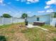 Backyard featuring a hot tub, grilling area, and fire pit with a white privacy fence at 4005 W Coachman Ave, Tampa, FL 33611