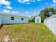 Spacious backyard with white fence, shed, and lush green grass, perfect for outdoor activities at 4005 W Coachman Ave, Tampa, FL 33611