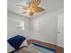 Bedroom featuring hardwood floors, a unique ceiling fan, and closet space for storage at 4005 W Coachman Ave, Tampa, FL 33611
