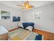 Bedroom featuring hardwood floors, a unique ceiling fan, and large windows with bright natural light at 4005 W Coachman Ave, Tampa, FL 33611