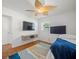 Bedroom featuring hardwood floors, two wall-mounted TVs, and a unique ceiling fan with great light at 4005 W Coachman Ave, Tampa, FL 33611
