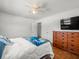 Bright bedroom with hardwood floors, ceiling fan, TV, and ample closet space for storage at 4005 W Coachman Ave, Tampa, FL 33611