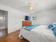 Well-lit bedroom with hardwood floors, ceiling fan, TV, and adjacent bathroom entrance for easy access at 4005 W Coachman Ave, Tampa, FL 33611