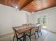 Charming dining room features wooden ceiling, a table with glass insert, seating for six and glass doors at 4005 W Coachman Ave, Tampa, FL 33611
