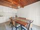 Dining room with a unique wood and glass table, modern light fixtures, and ample cabinet space at 4005 W Coachman Ave, Tampa, FL 33611