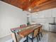 Chic dining room with stylish light fixtures, wood ceiling, glass insert dining table and seating for 6 at 4005 W Coachman Ave, Tampa, FL 33611