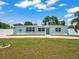 Charming home with well-maintained lawn, light blue exterior, and a paved driveway at 4005 W Coachman Ave, Tampa, FL 33611