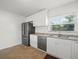 Well-lit kitchen showcasing stainless steel appliances, white cabinets, granite countertops, and tile flooring for a clean look at 4005 W Coachman Ave, Tampa, FL 33611