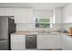 Well-lit kitchen with white cabinets, stainless steel appliances and granite countertops, providing a functional cooking space at 4005 W Coachman Ave, Tampa, FL 33611