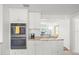 Elegant kitchen with built-in oven, stainless steel appliances, white cabinets, and granite countertops, perfect for meal preparation at 4005 W Coachman Ave, Tampa, FL 33611