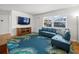 Bright living room featuring hardwood floors, a blue sofa, and a decorative palm-leaf rug at 4005 W Coachman Ave, Tampa, FL 33611
