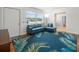Bright living room featuring hardwood floors, a blue sofa, a palm-leaf rug, and lots of natural light at 4005 W Coachman Ave, Tampa, FL 33611