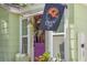 Close-up of a vibrant purple front door, with sidelights, decorative wreath and Crescent Lake flag at 427 21St N Ave, St Petersburg, FL 33704
