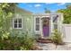 Charming home with a light green exterior, white trim, and a vibrant purple front door with a festive wreath at 427 21St N Ave, St Petersburg, FL 33704