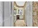 Hallway leading to bathroom with a sink, vanity and stone wall at 4388 Tiffin Ave, Spring Hill, FL 34609