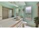 Bright bathroom featuring a white vanity, spacious mirror, and tiled shower at 4388 Tiffin Ave, Spring Hill, FL 34609