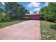 Single-story home featuring an expansive driveway and mature landscaping at 4388 Tiffin Ave, Spring Hill, FL 34609