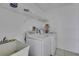 Bright laundry room features a utility sink, washer, dryer and storage space at 4388 Tiffin Ave, Spring Hill, FL 34609