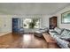 Well-lit living room with hardwood floors and large windows overlooking the landscape at 4388 Tiffin Ave, Spring Hill, FL 34609