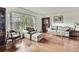 Bright living room featuring hardwood floors, large window, and comfortable floral furnishings at 4388 Tiffin Ave, Spring Hill, FL 34609