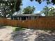 Charming single-story home featuring a fenced yard with mature trees providing shade and privacy at 440 53Rd N St, St Petersburg, FL 33710