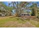 Large backyard with mature trees, open lawn, and swing set at 525 Gornto Lake Rd, Brandon, FL 33510