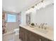 Well-lit bathroom featuring double vanity, modern fixtures, and glass block window at 525 Gornto Lake Rd, Brandon, FL 33510
